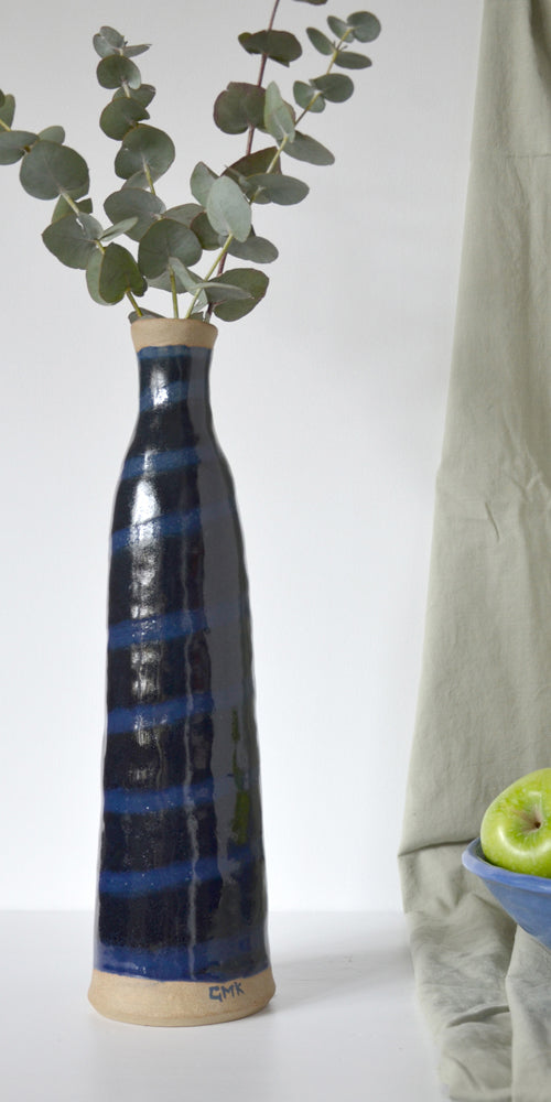 Tall jar style vase in a glossy black and dark blue swirl design